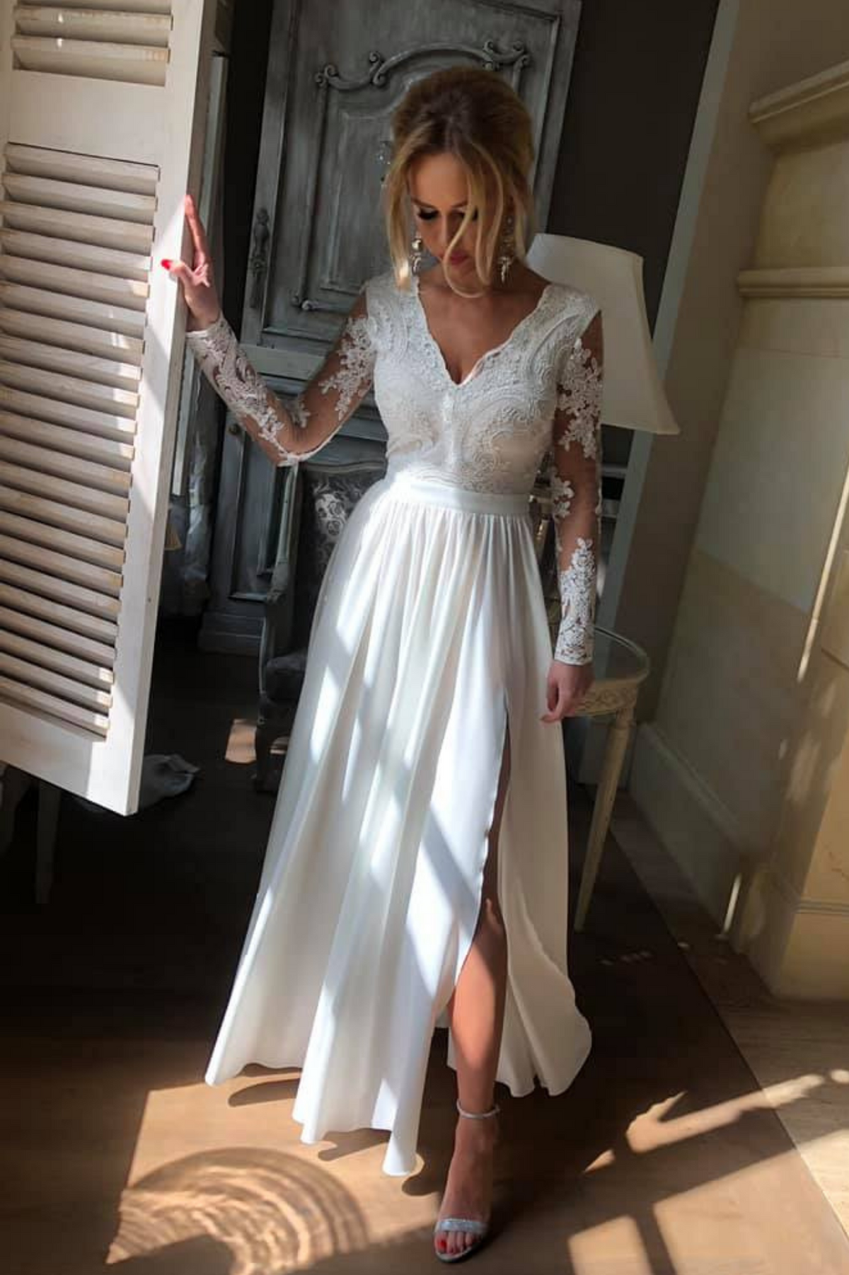 Abito lungo svasato bianco con spacco laterale e corpetto in tulle ricamato, firmato Moda-Mania, visualizzato su modella.