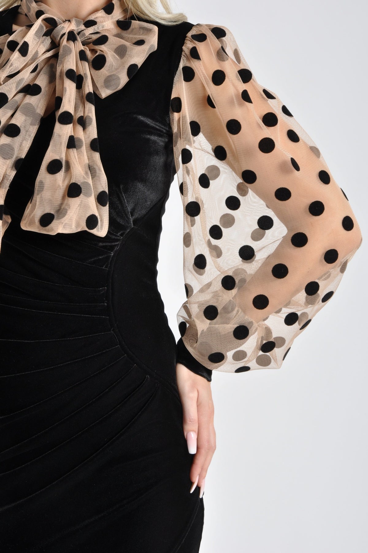 Abito corto nero in velluto con maniche in tulle nude a pois neri, vestibilità elegante e dettagli femminili di Moda-Mania.