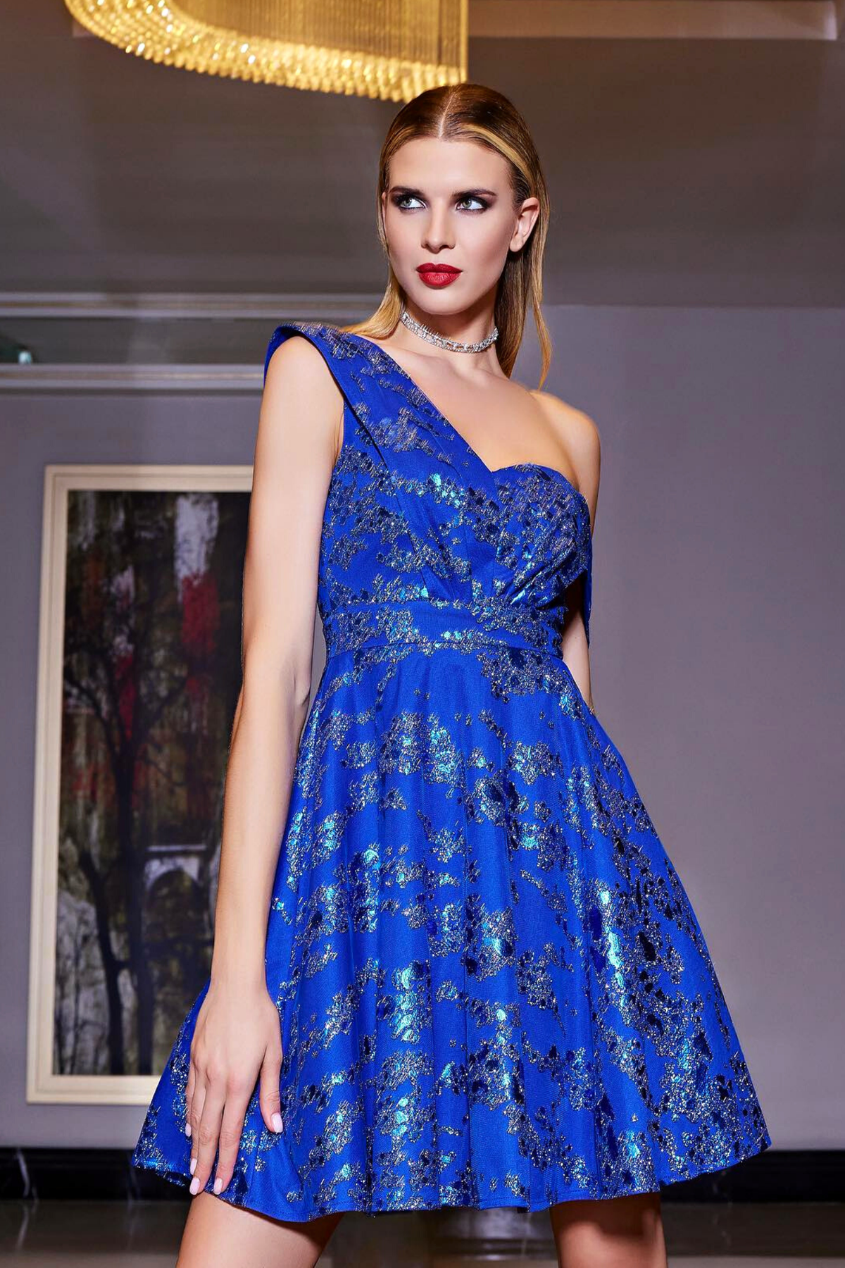 Abito corto svasato blu elettrico con fantasia glitterata e spalla cadente, moda-mania, ideale per eventi eleganti.
