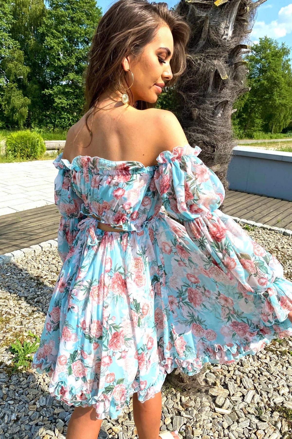 Abito estivo corti Moda-Mania celeste con fantasia floreale rosa, apertura sul dietro e maniche lunghe rimovibili.