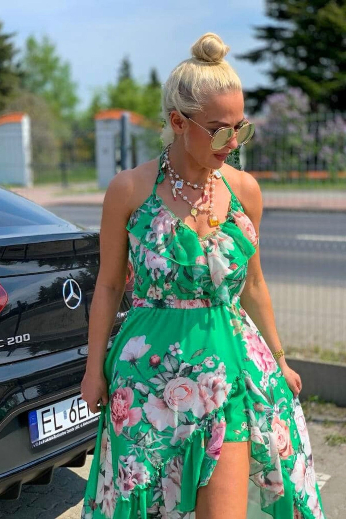 Abito estivo verde acqua a fantasia floreale, corto davanti, lungo dietro, allacciabile al collo e rifinito da volants, Moda-Mania.