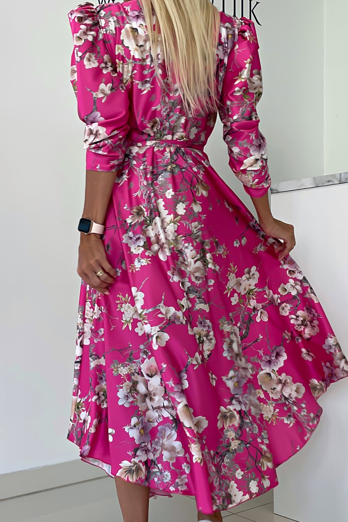 Abito midi fucsia svasato con fantasia floreale, maniche a sbuffo e allacciatura in vita, firmato Moda-Mania.