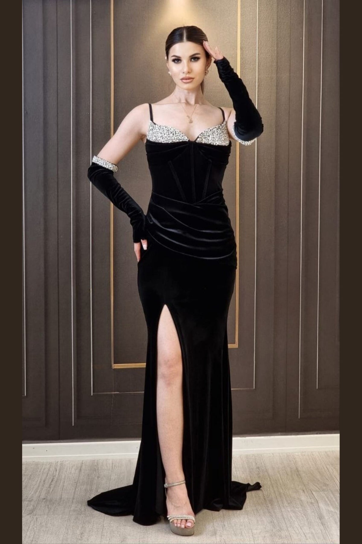 Abito lungo aderente nero in velluto con cristalli, guanti e spacco laterale, firmato Moda-Mania, elegante e sofisticato.