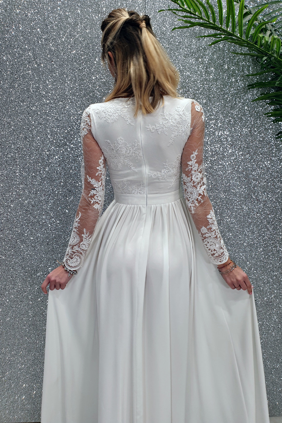 Abito lungo svasato bianco Moda-Mania con spacco laterale e corpetto in tulle ricamato, elegante e femminile.