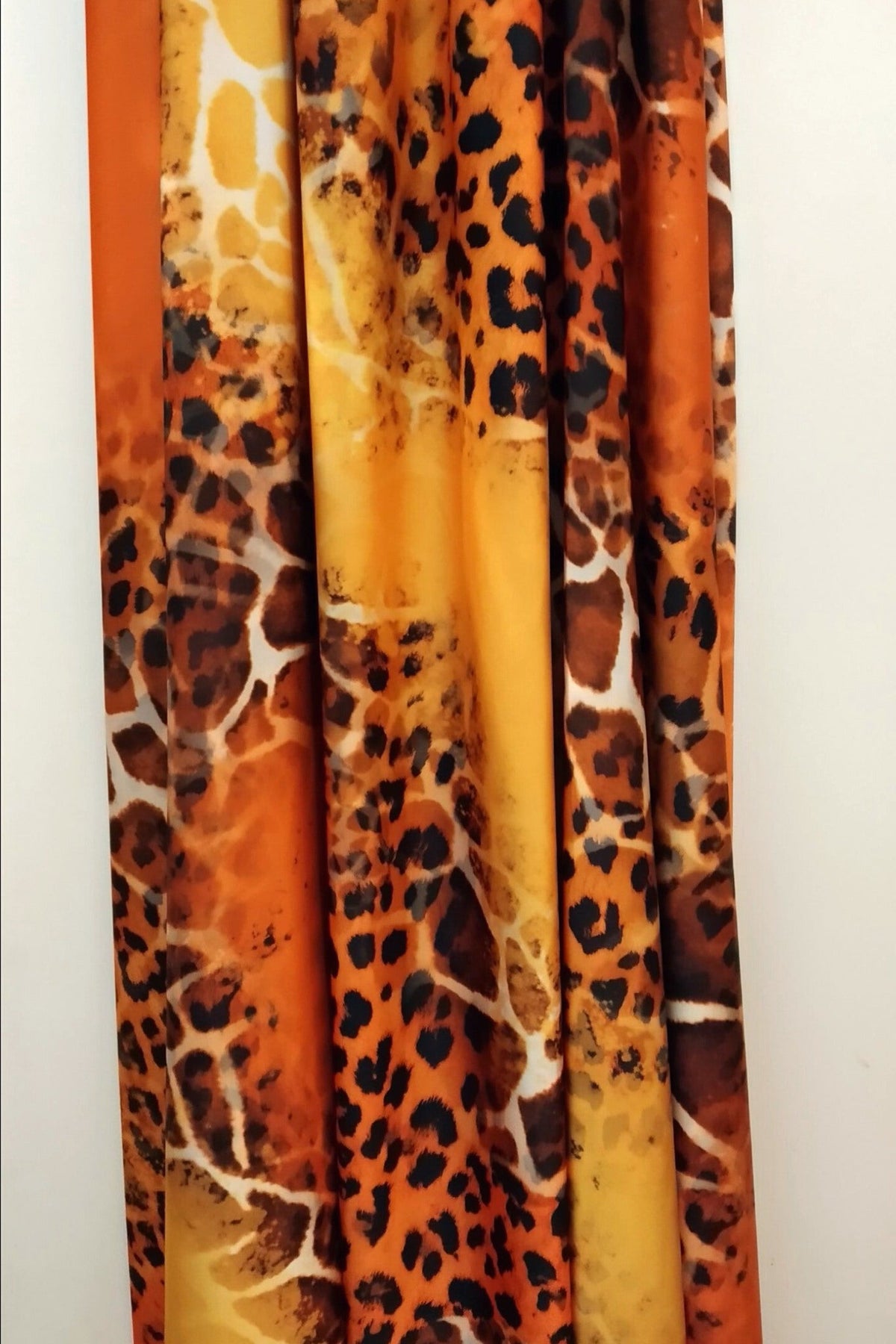 Abito lungo svasato estivo arancione con fantasia leopardata e scollo a barchetta in tessuto satinato, brand Moda-Mania.
