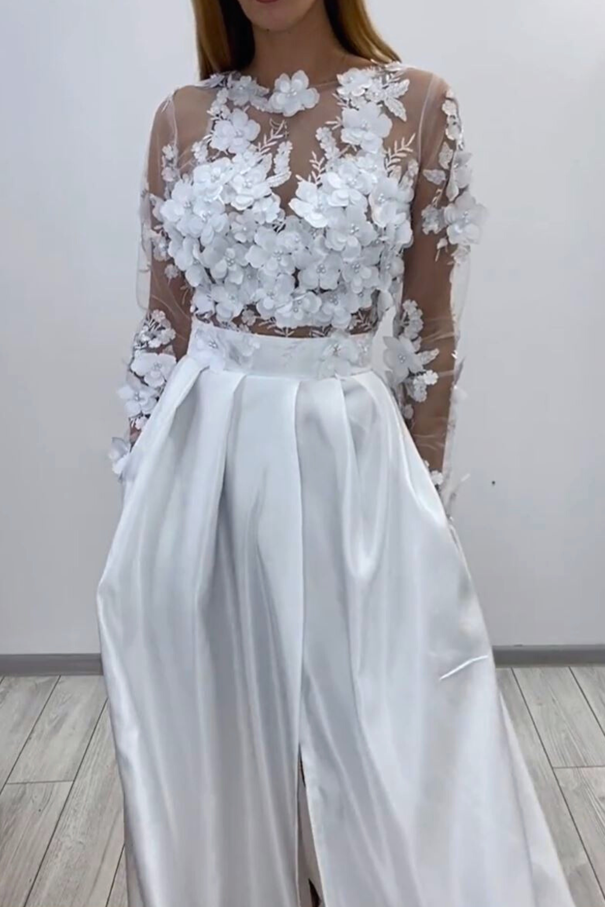 Abito lungo svasato bianco Moda-Mania con corpetto a manica lunga in tulle floreale 3D e gonna in taffetà, vista frontale.
