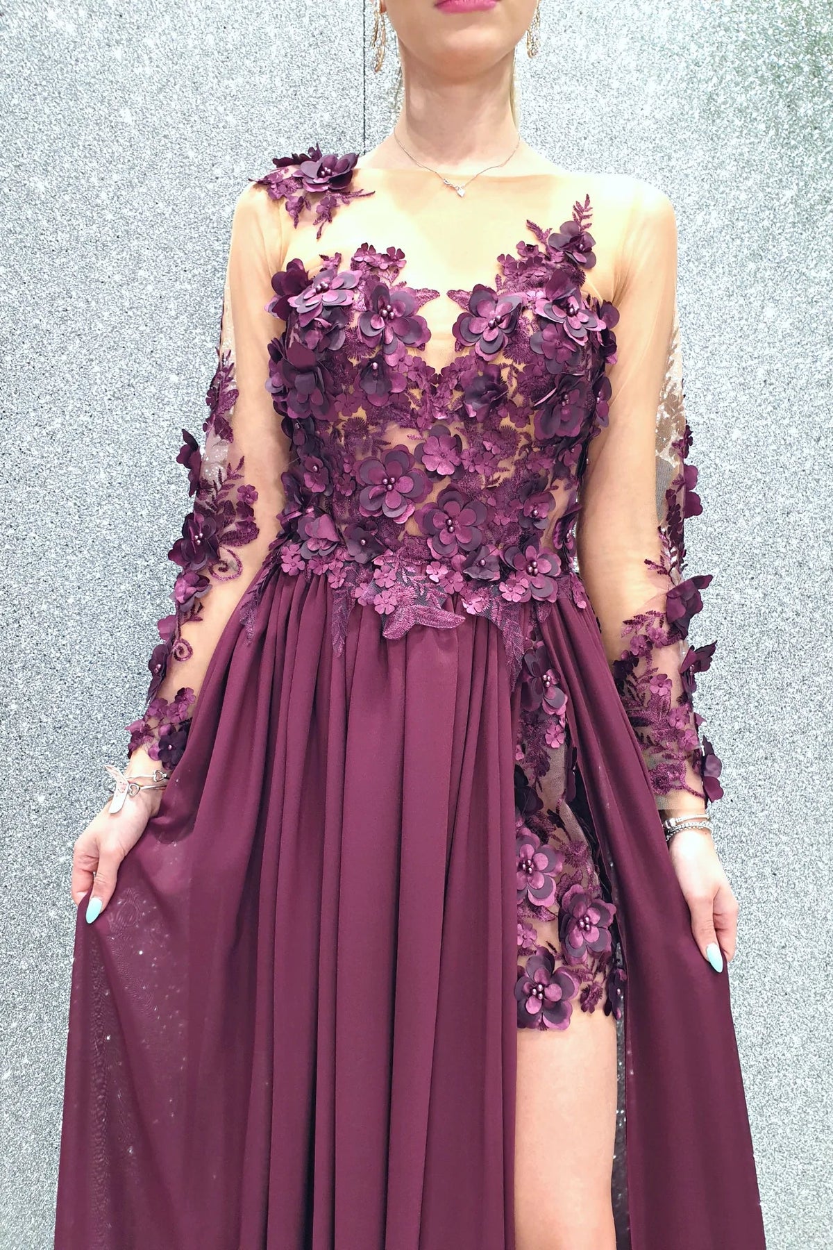 Abito lungo viola prugna Moda-Mania con strascico e corpetto in tulle nude a fiori 3D, dettaglio elegante e femminile.