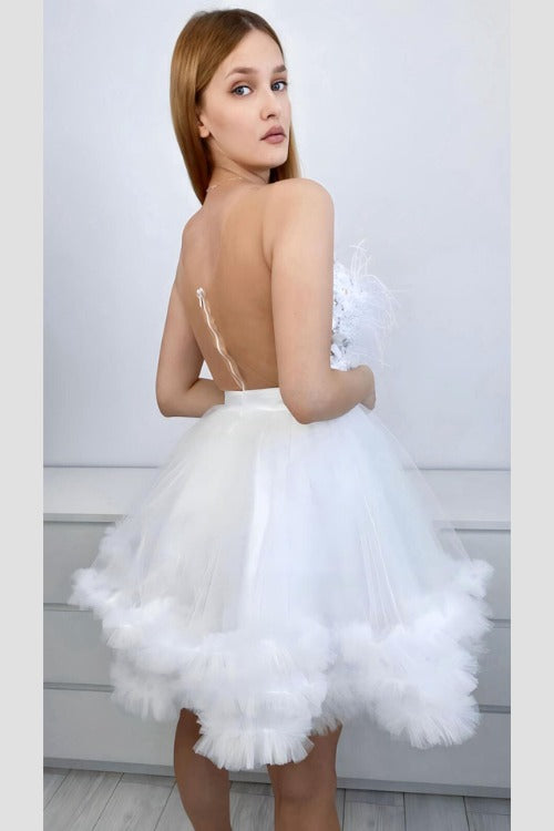 Abito princess bianco Moda-Mania, corto in tulle con corpetto a fiori 3D e dettagli di piume decorativa.