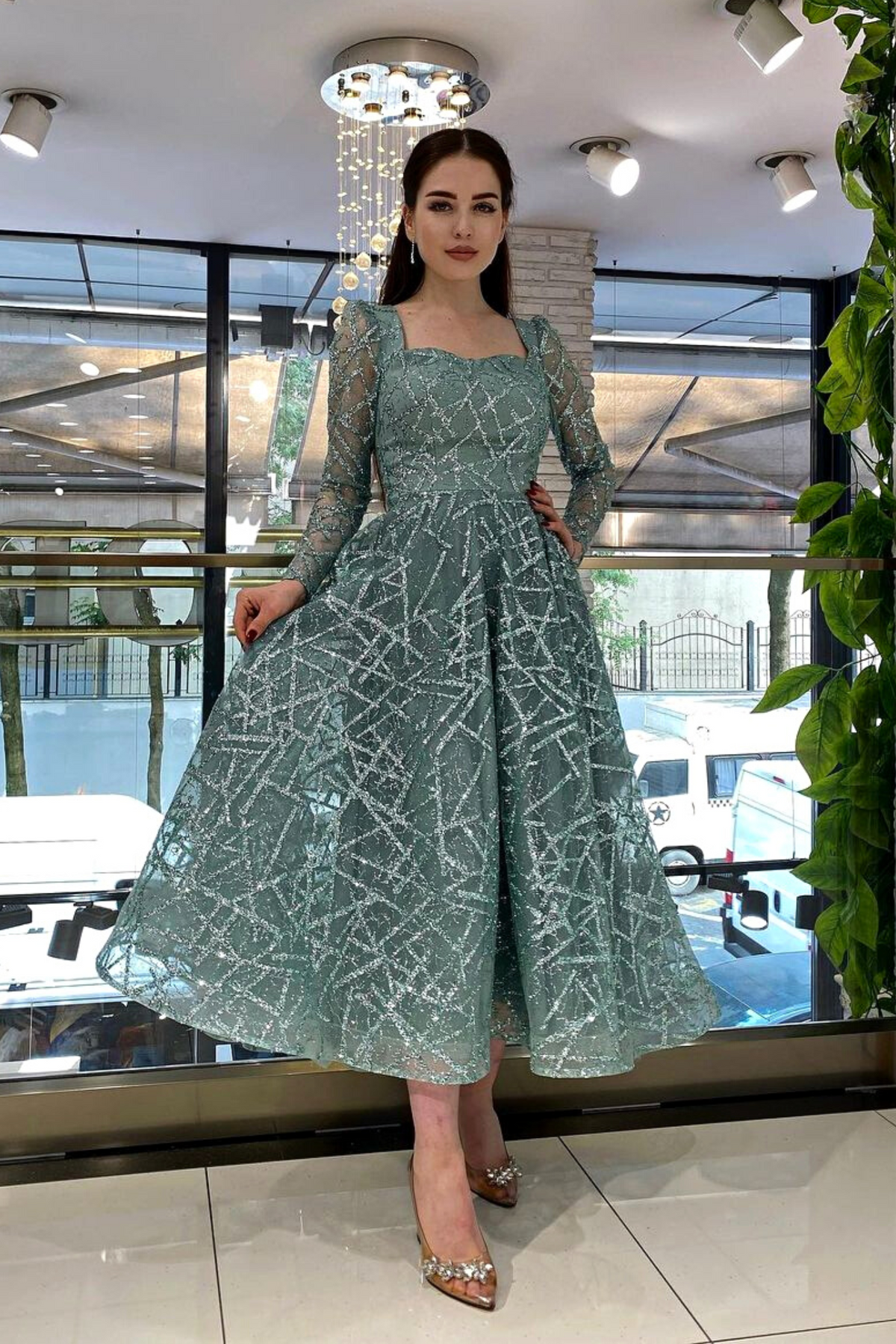 Abito svasato midi verde menta in tulle con trama glitterata, maniche lunghe, firmato Moda-Mania.