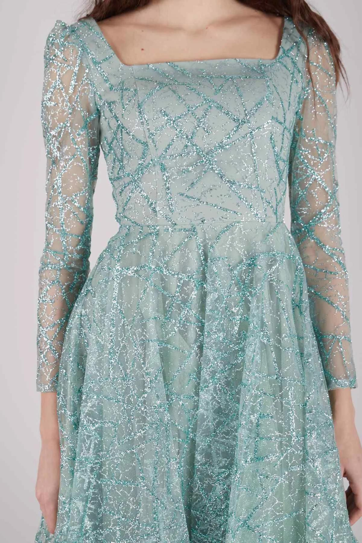 Abito svasato midi verde menta in tulle con trama glitterata e maniche lunghe, firmato Moda-Mania.