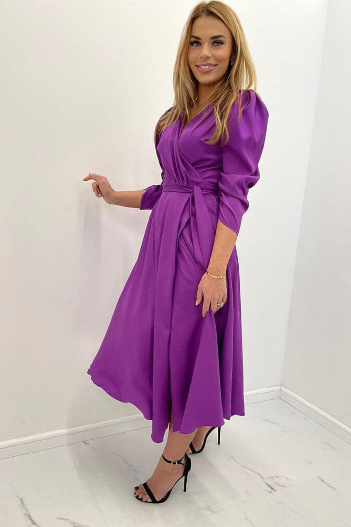 Abito lungo svasato viola con maniche a sbuffo, allacciabile in vita e spacco laterale, marca Moda-Mania.