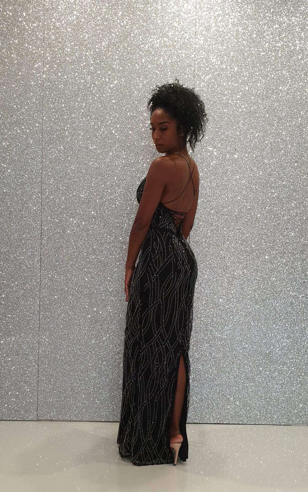 Abito lungo nero Bby con scollatura profonda, schiena scoperta e dettagli incrociati, in tessuto elegante e di moda.
