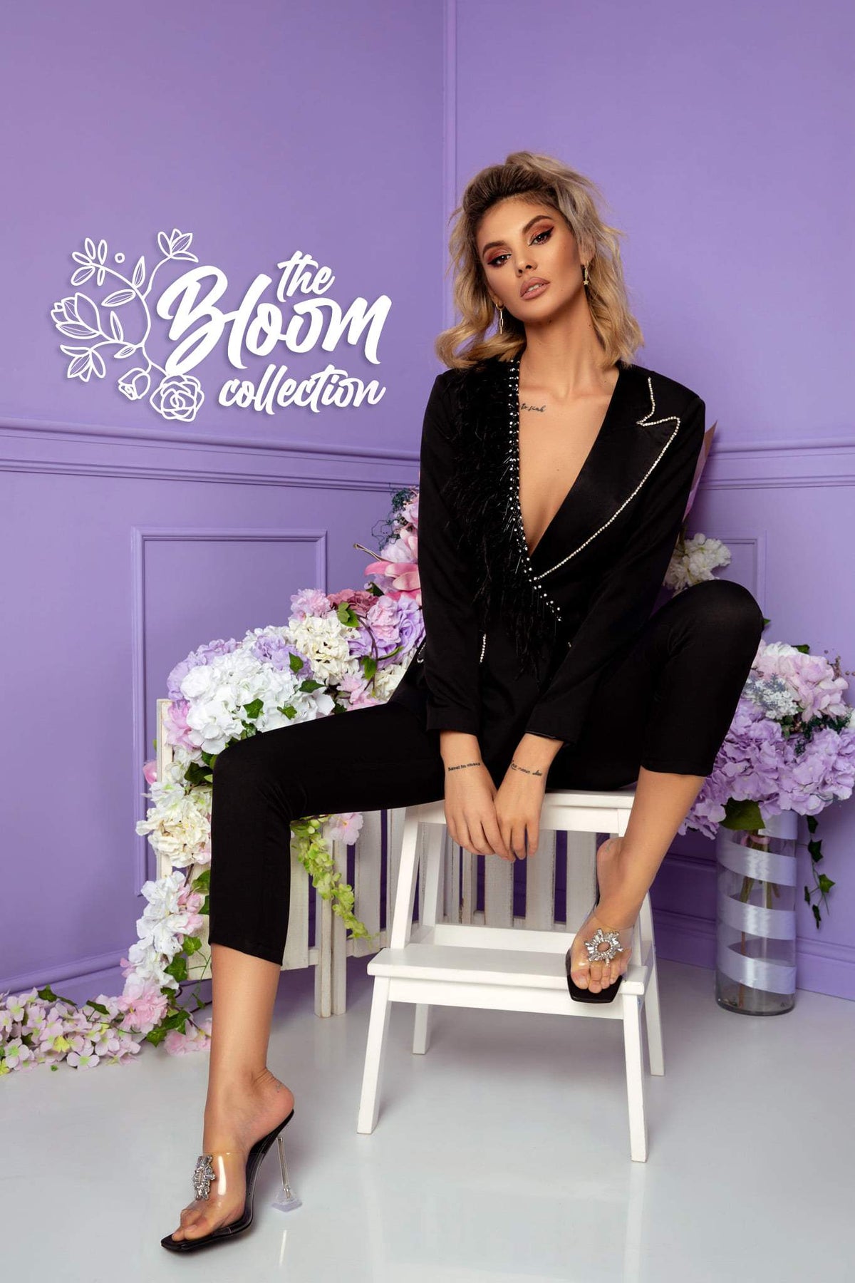 Completo tailleur nero elegante Bby con rifiniture in strass, revers a V e accessorio con piume, perfetto per occasioni speciali.