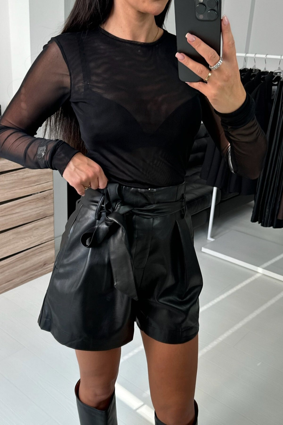 Blusa nera aderente a manica lunga in tessuto rete elasticizzato di Moda-Mania, mostra i dettagli del tessuto trasparente e fit.