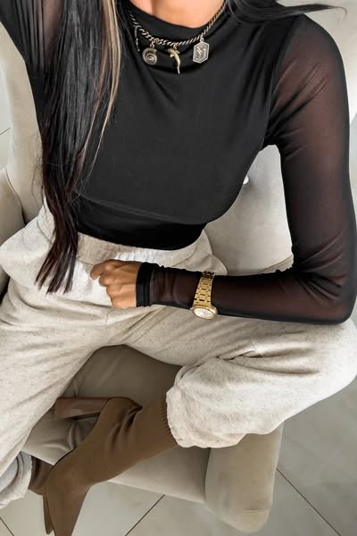 Blusa aderente nera a manica lunga in tulle stretch elasticizzato, prodotto Moda-Mania, dettaglio di tessuto trasparente e aderente.