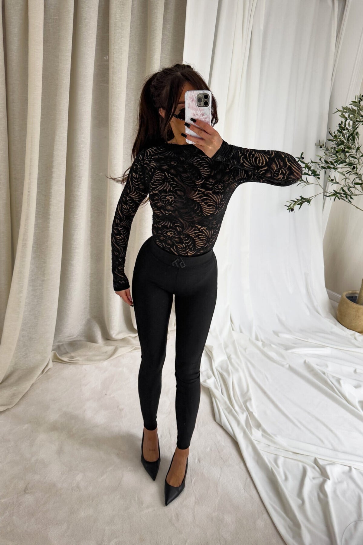 Blusa aderente nera Moda-Mania a maniche lunghe in pizzo elasticizzato con fantasia floreale, dettagli eleganti e femminili.