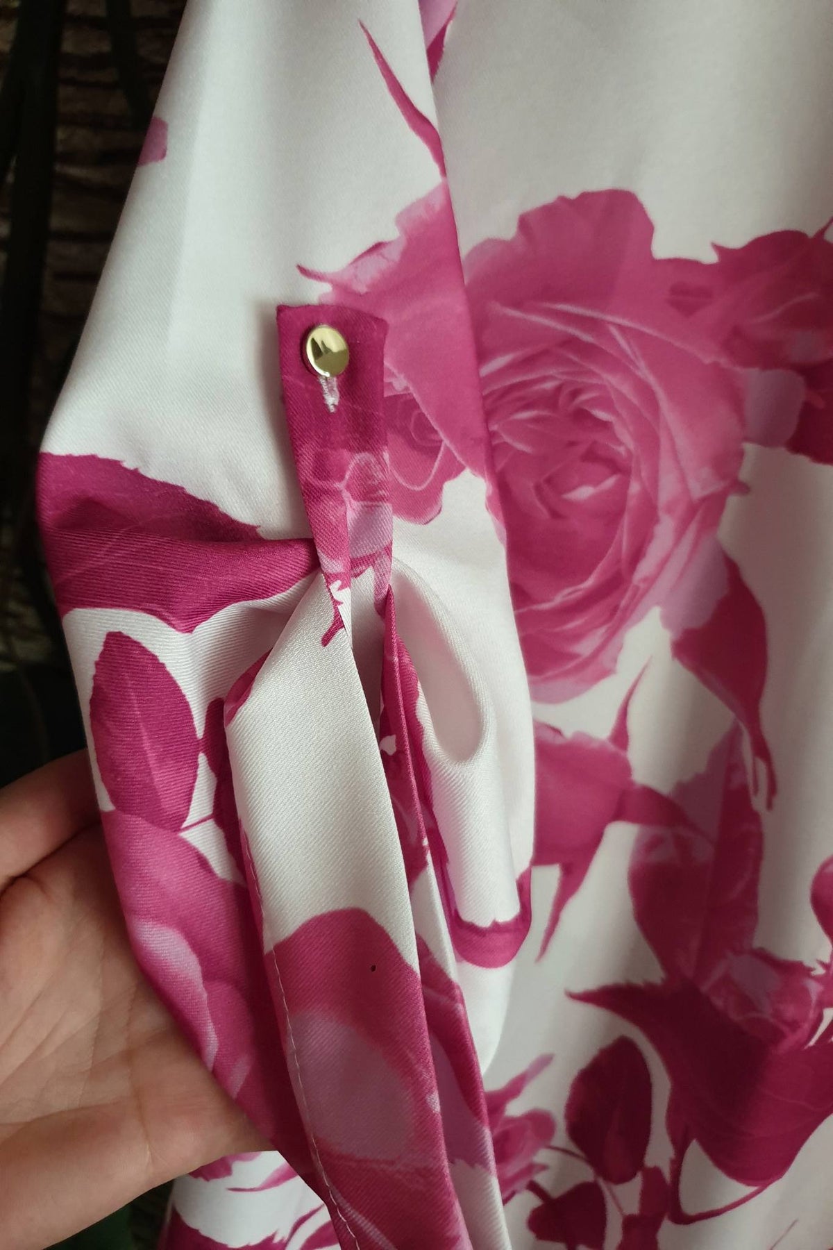 Blusa bianca con fantasia floreale fucsia, maniche tre quarti e bottoni dorati, marca Moda-Mania, dettaglio di moda femminile.