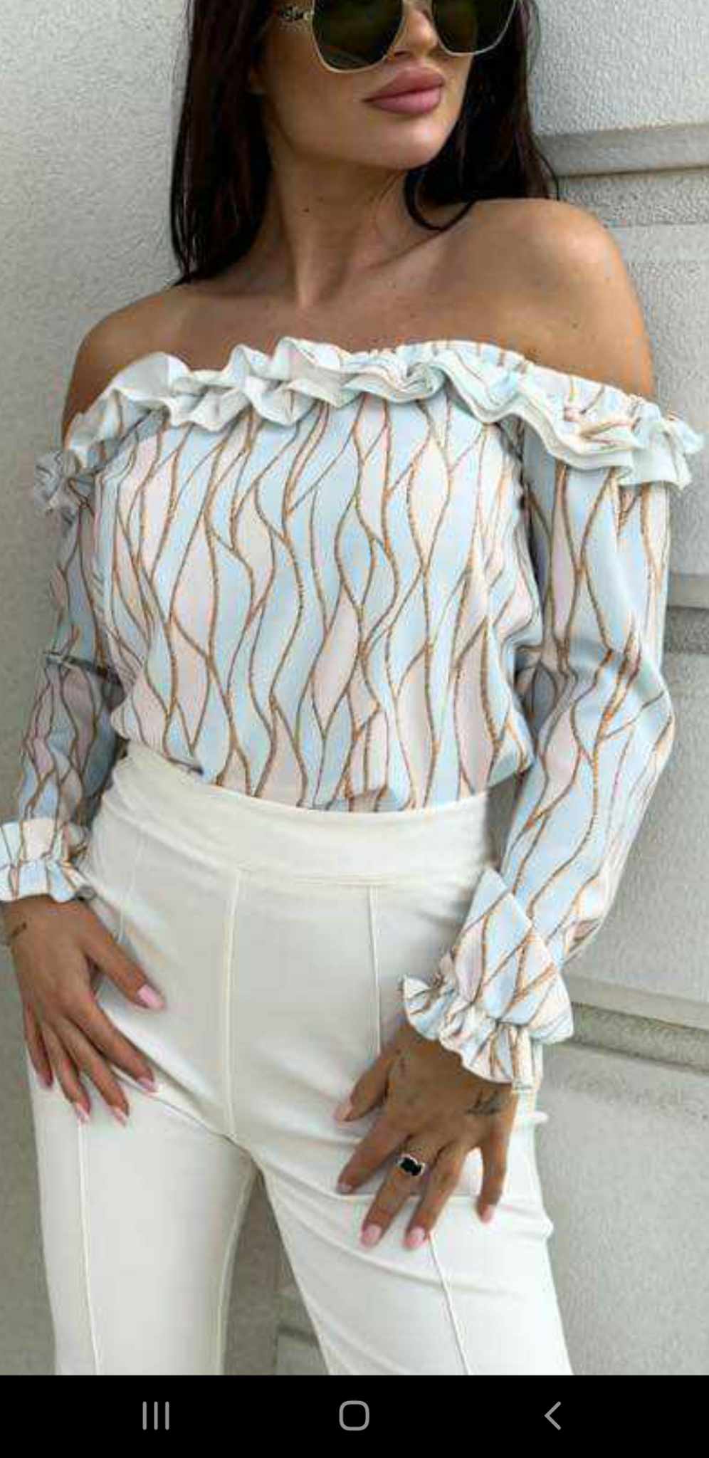 Blusa celeste a fantasia astratta con scollo a barchetta e rifiniture rouches, brand Moda-Mania, vestibilità elegante e femminile.