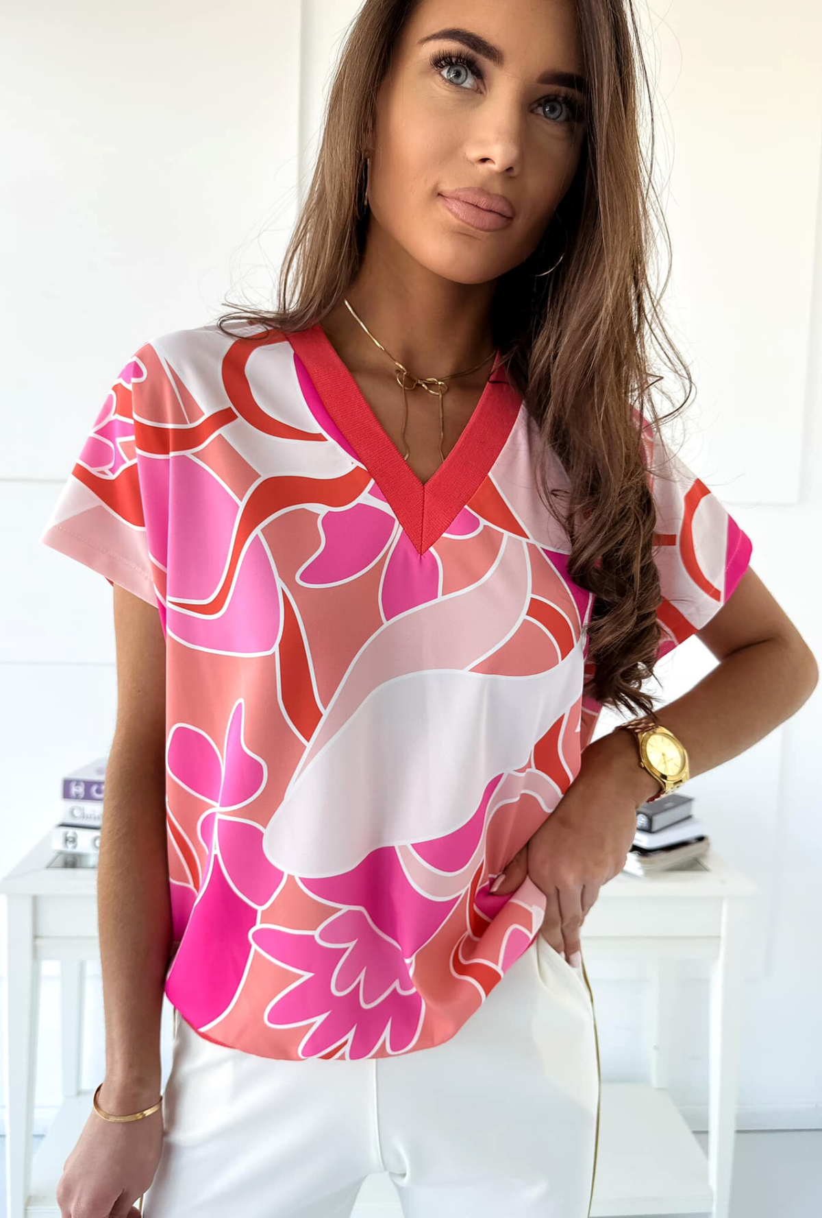 Blusa estiva Moda-Mania con maniche corte, fantasia astratta in tonalità corallo e fucsia, tessuto leggero e fresco.