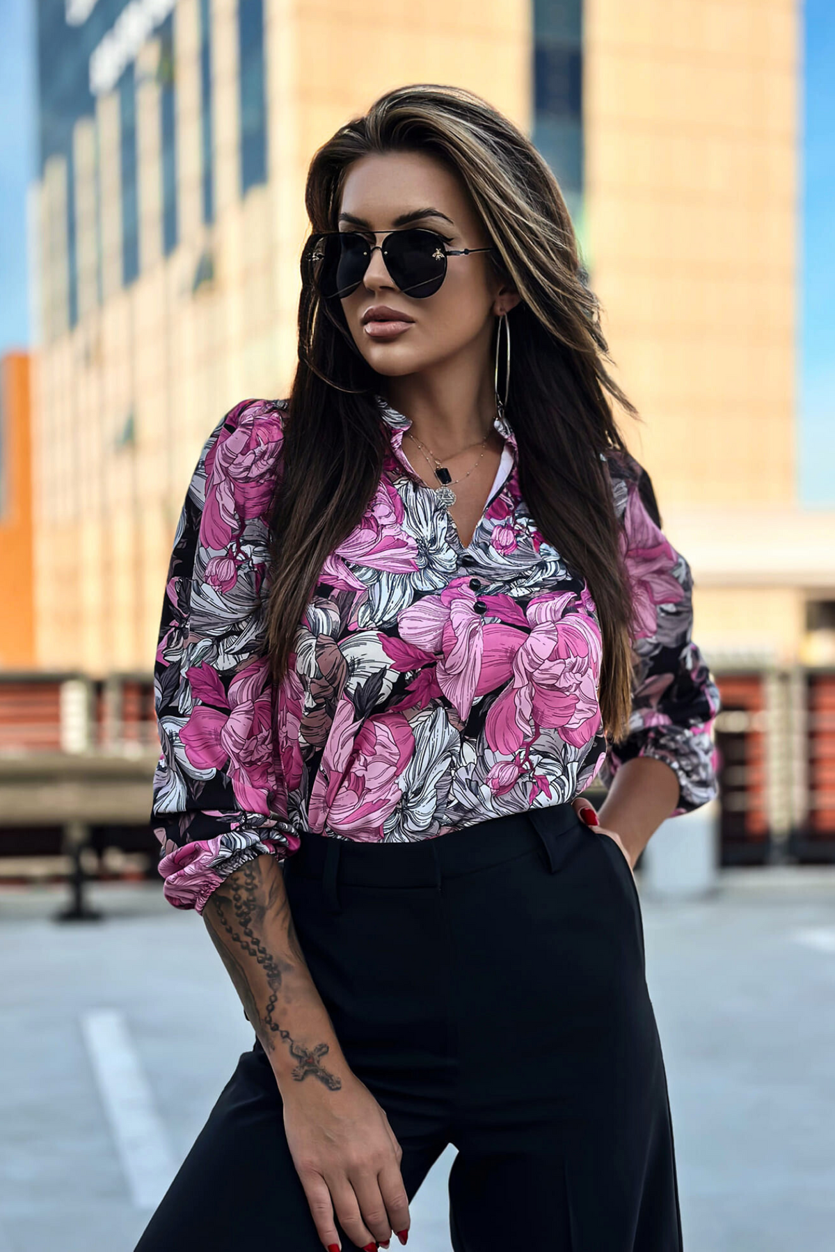 Blusa nera Moda-Mania con stampa floreale fucsia e bianca, scollo a V e bottoncini, vista frontale.