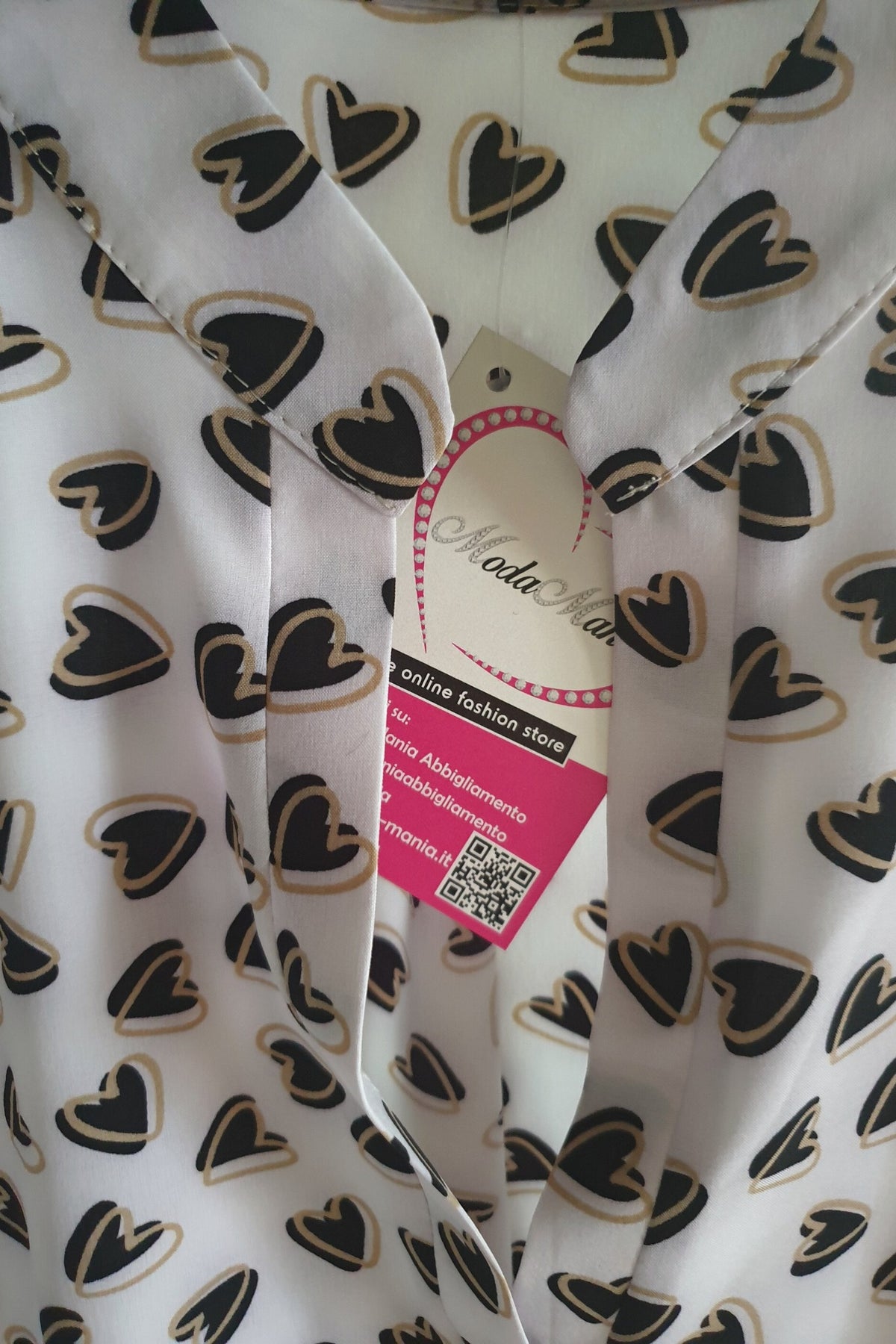 Camicia bianca Moda-Mania a fantasia cuori neri e beige, scollo a V, bottoni dorati, tessuto leggero e stile elegante