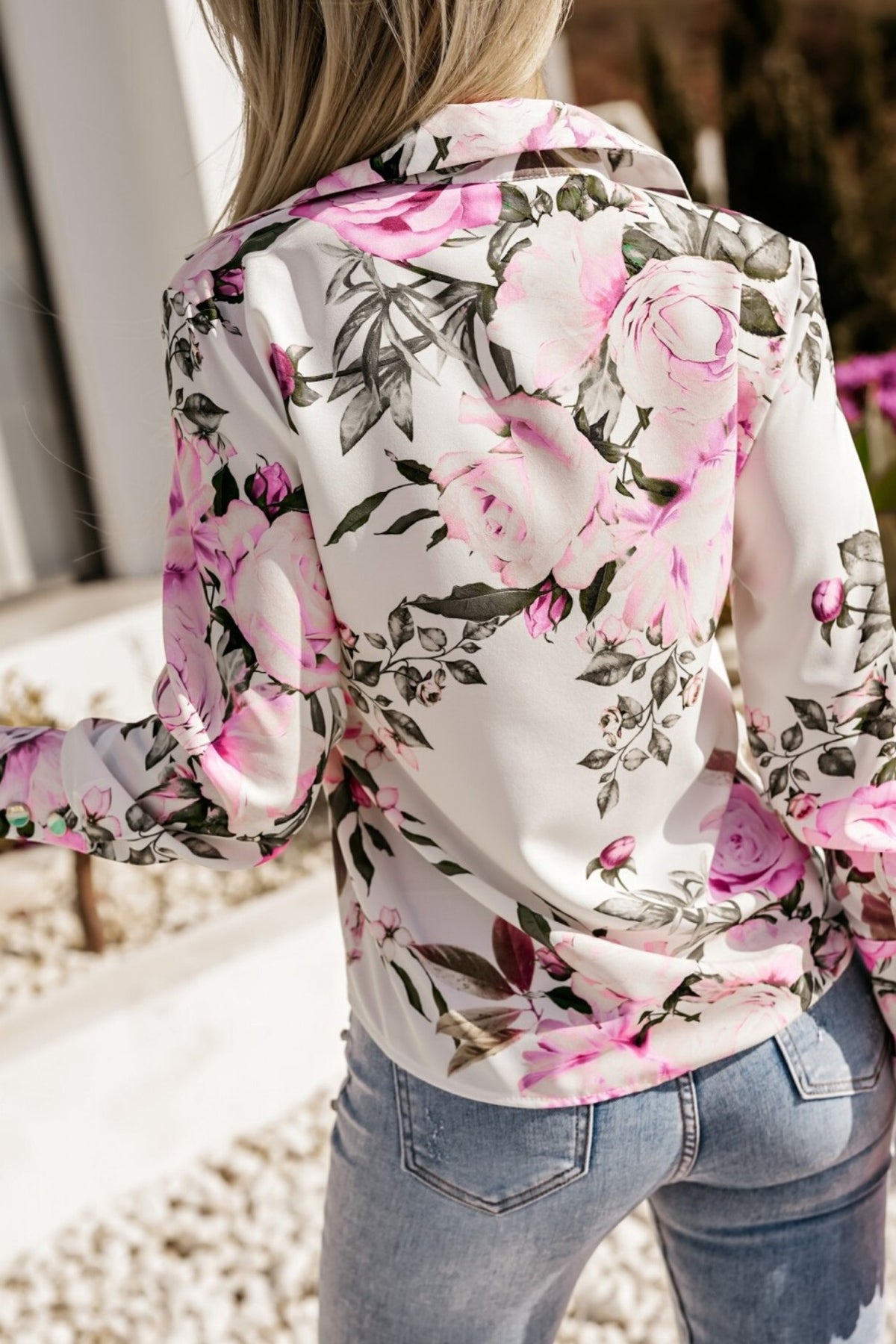 Camicia elegante bianca Moda-Mania con fantasia floreale rosa e fucsia e bottoni dorati, dettagli raffinati e stile sofisticato.