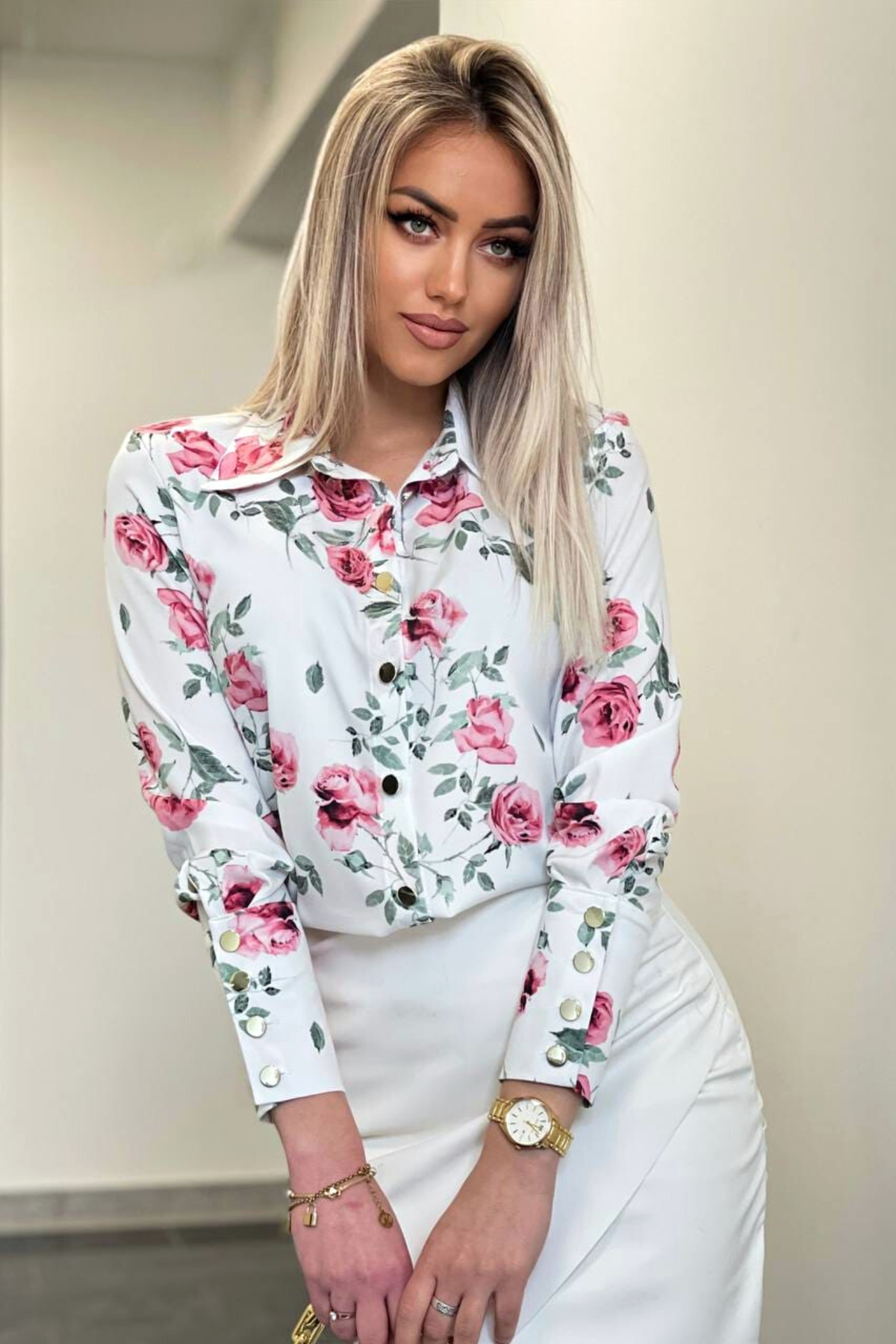 Camicia elegante bianca Moda-Mania con fantasia floreale rossa e rosa, bottoni dorati, tessuto leggero e dettagli raffinati.