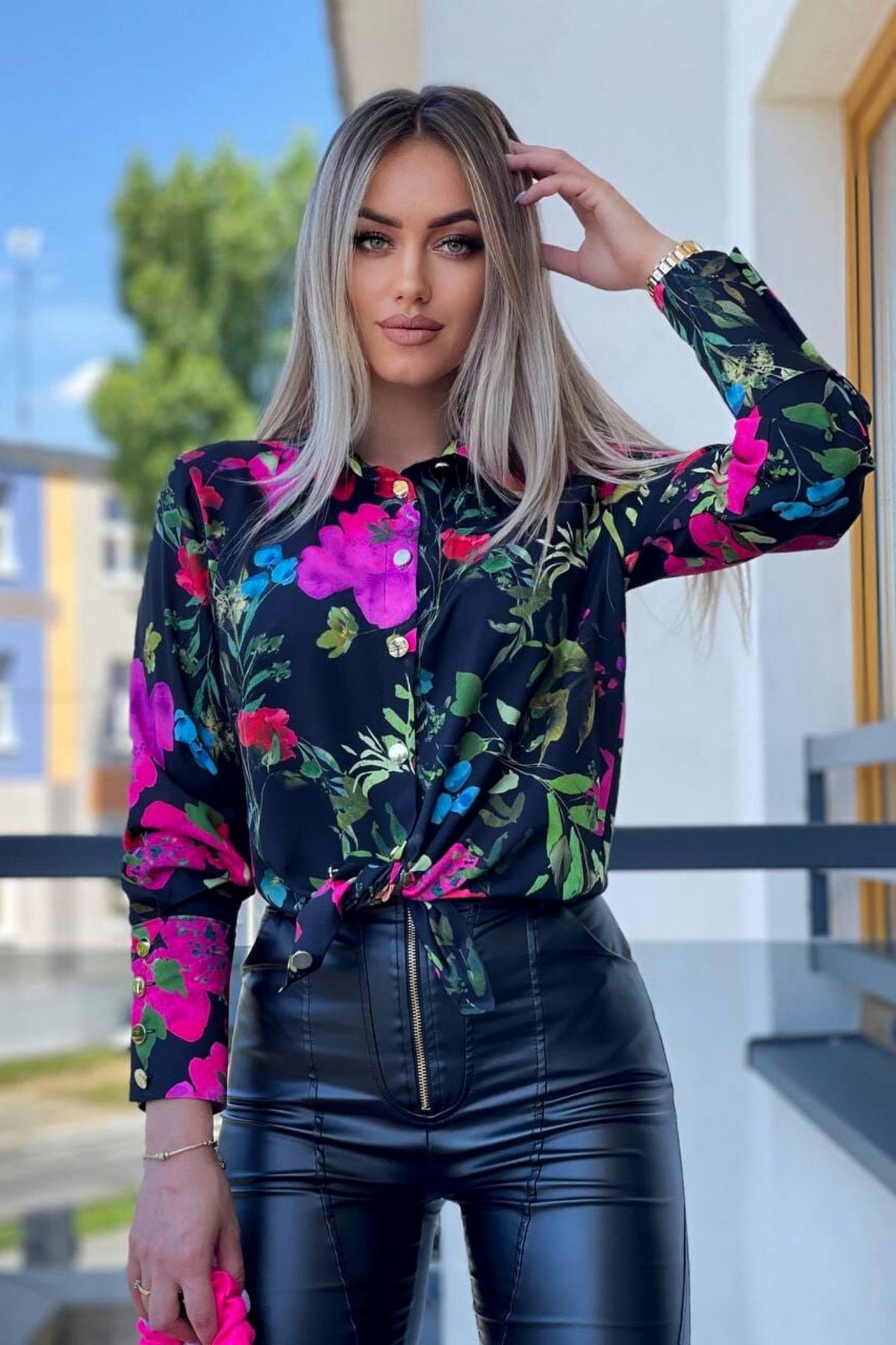 Camicia elegante nera Moda-Mania con fantasia floreale multicolore e bottoni dorati, tessuto leggero e dettagli raffinati.
