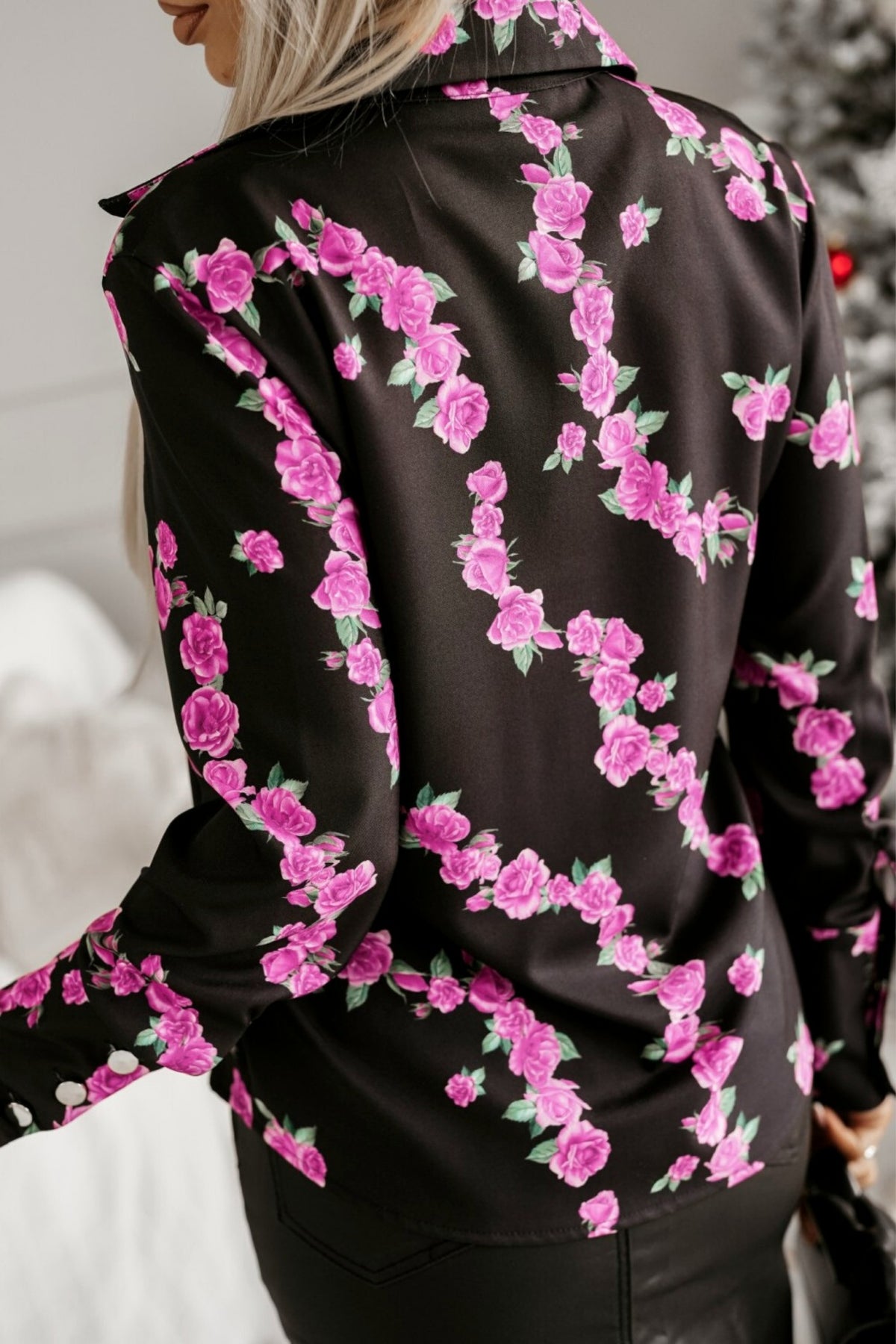 Camicia elegante nera Moda-Mania con fantasia di piccole rose fucsia e bottoni dorati, tessuto leggero e dettagli raffinati.