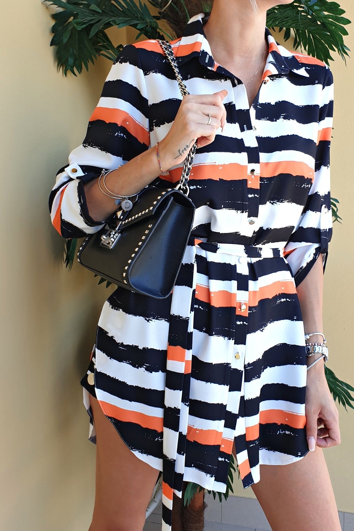 Camicia lunga bianca Moda-Mania con fantasia righe nere e arancioni, spacchi laterali e cinturino, abiti corti eleganti.