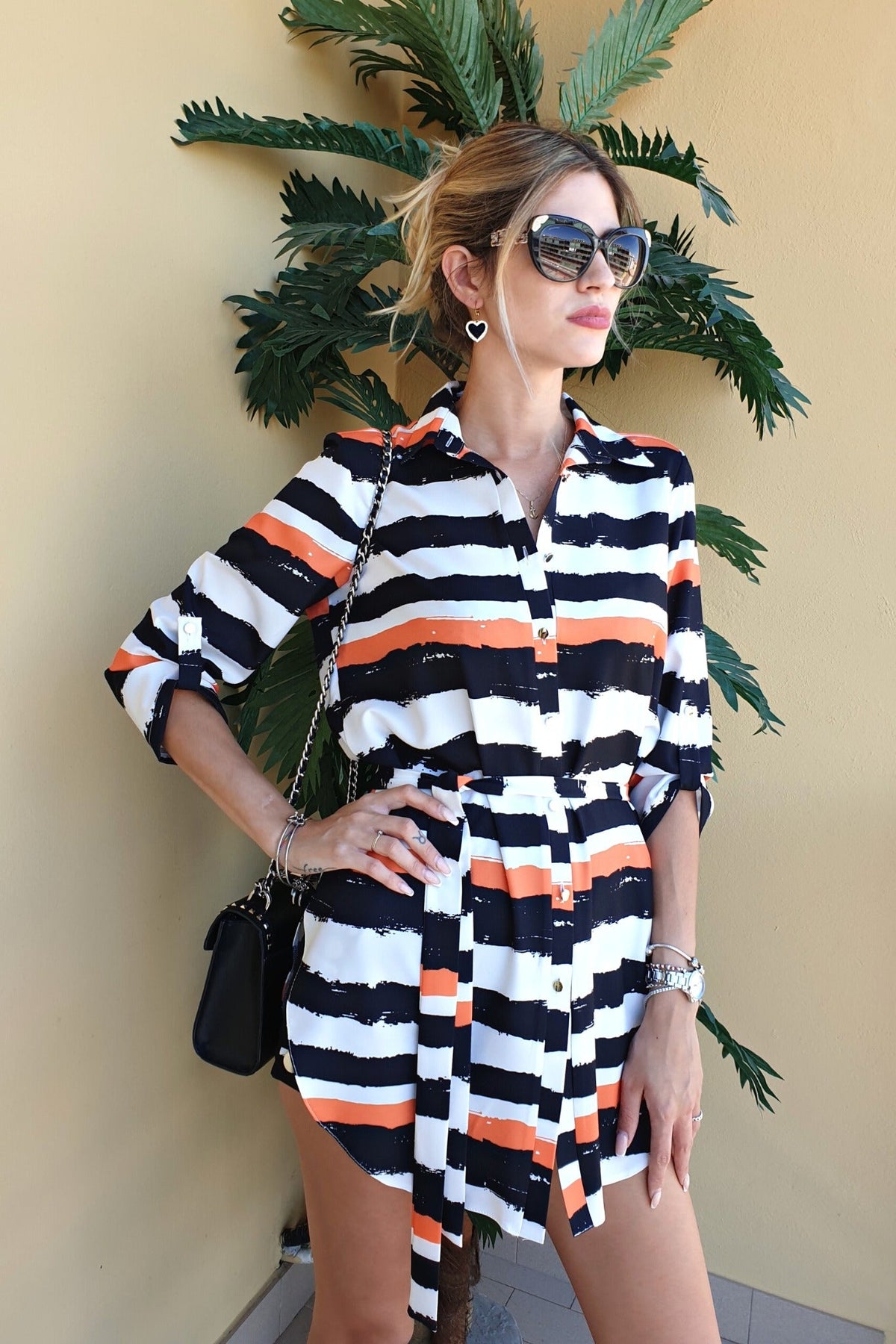 Camicia lunga bianca Moda-Mania con fantasia a righe nere e arancioni, spacchi laterali e cinturino, abiti corti eleganti.
