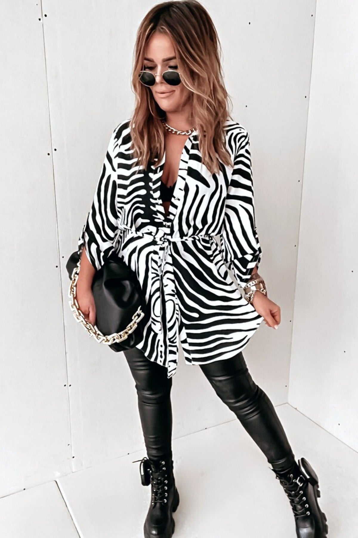 Camicia lunga bianca a fantasia zebrata nera con spacchi laterali e cinturino, camicia Moda-Mania, tessuto leggero e stile elegante.