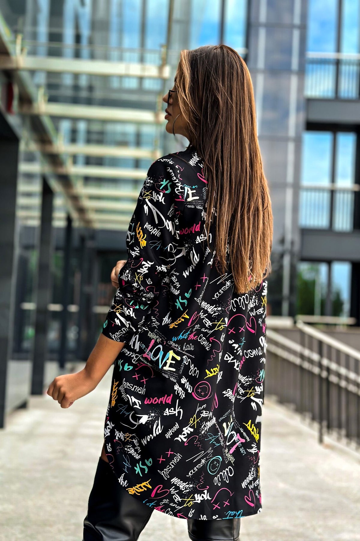 Camicia oversize nera Moda-Mania con scritte multicolore, tessuto morbido e stile casual, visibile con dettagli delle scritte colorate.