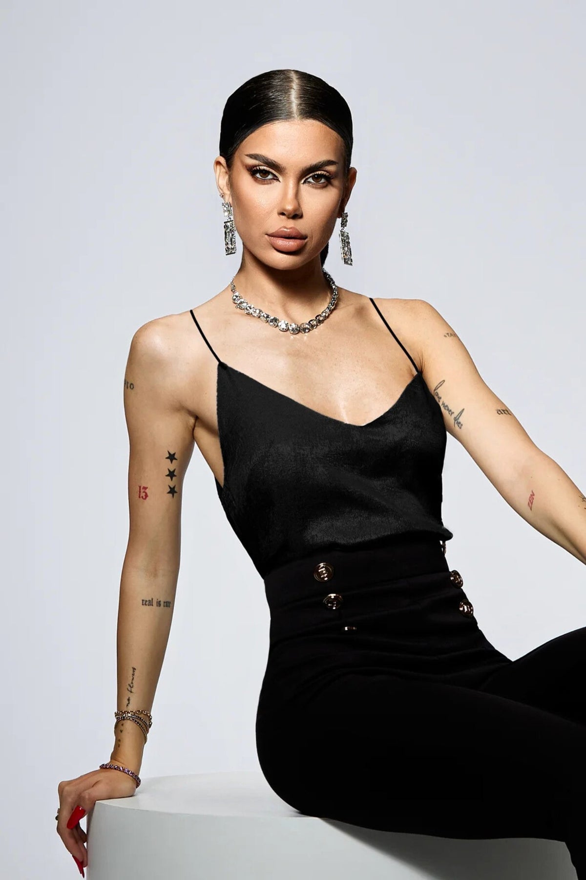 Canotta elegante nera Bby in tessuto satinato con spalline sottili, ideale per look sofisticati e femminili.