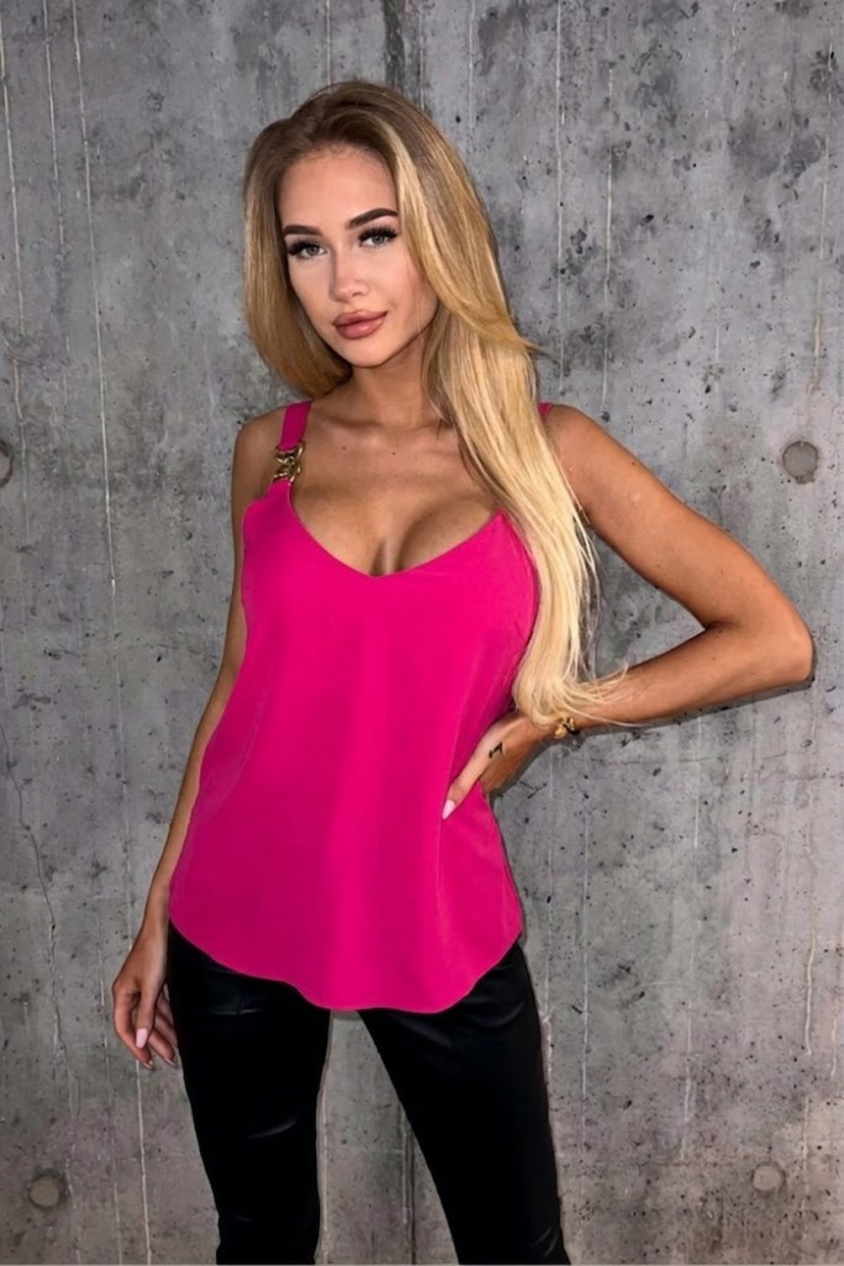 Canotta fucsia Moda-Mania con scollo profondo e spalline accessoriate, dettaglio di stile e colore vivace.