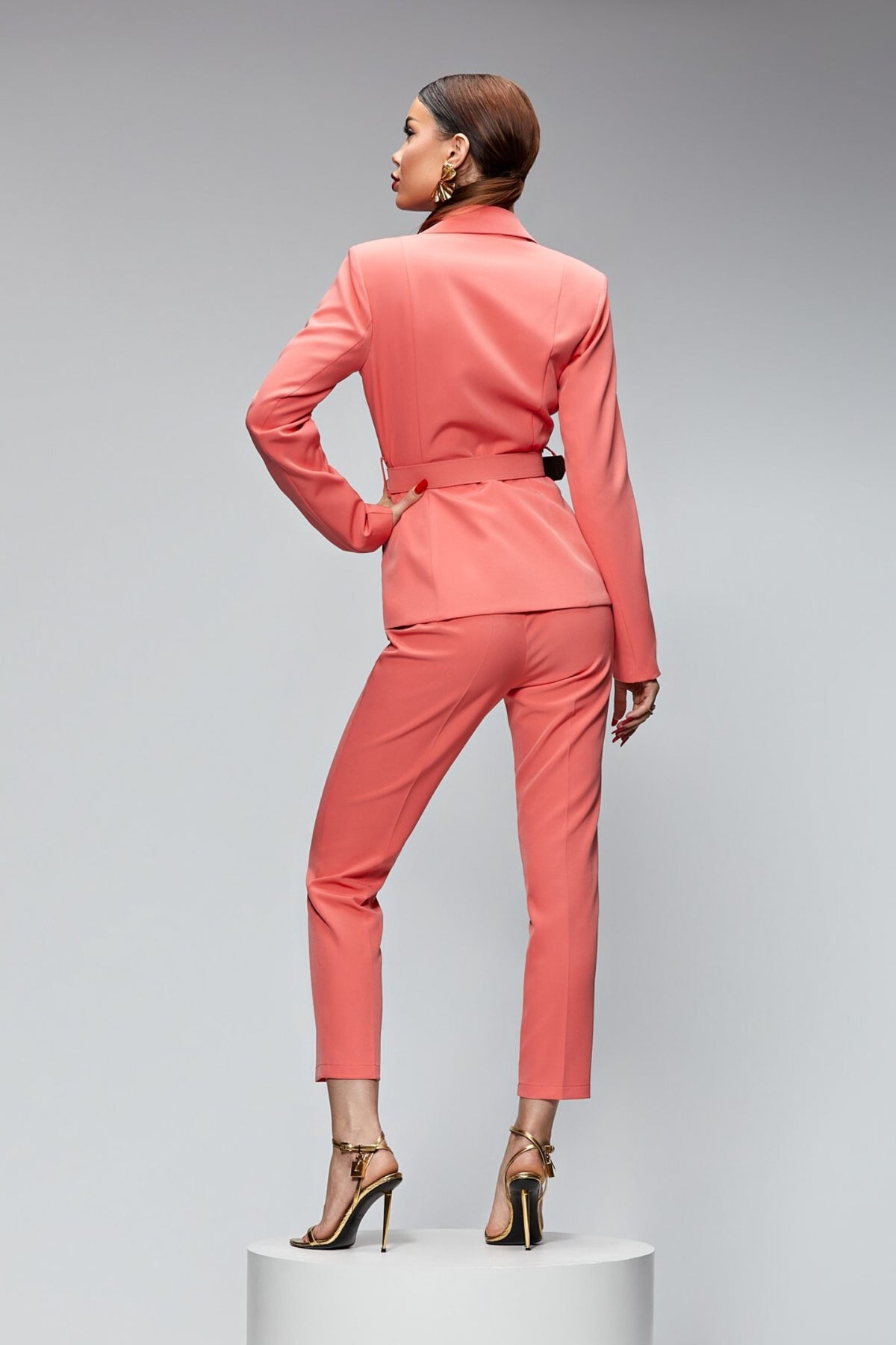 Completo tailleur elegante salmone Bby con giacca e pantalone, cintura con fibbia dorata, stile sofisticato e femminile.