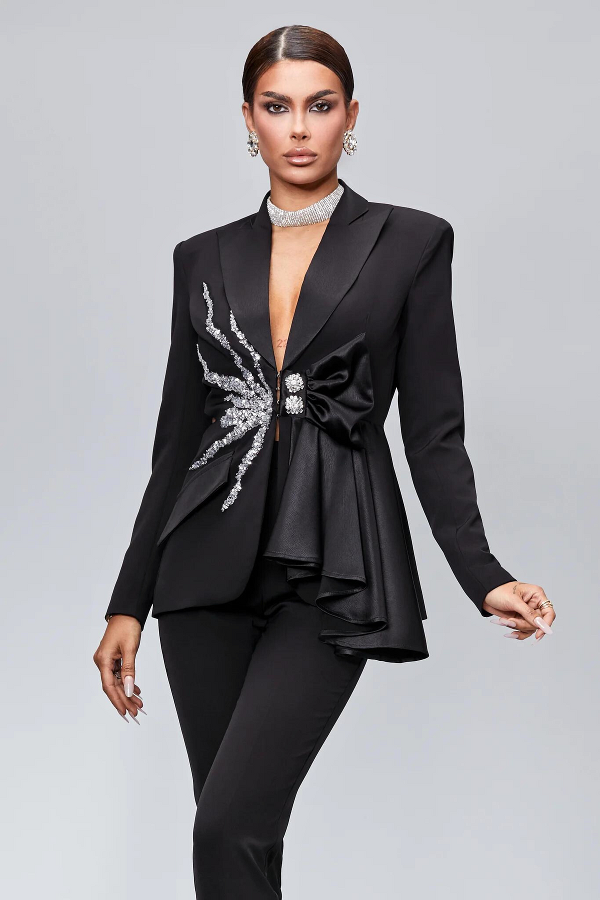 Completo tailleur nero Bby con decorazioni argento, volant, fiocco e taglio in vita, giacca e pantalone eleganti.