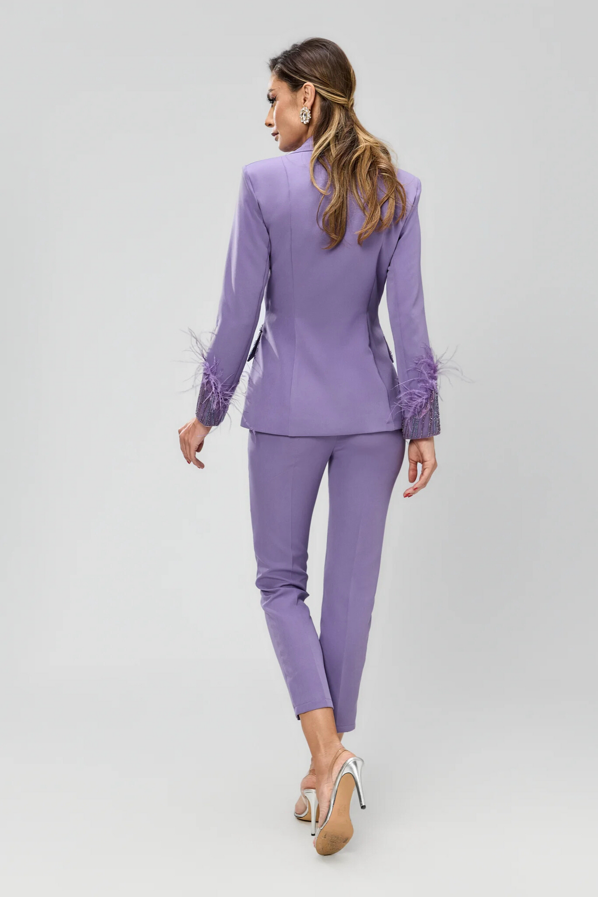 Completo tailleur Bby in lilla con giacca impreziosita da piume e ricami in perline, pantaloni a sigaretta eleganti e raffinati.