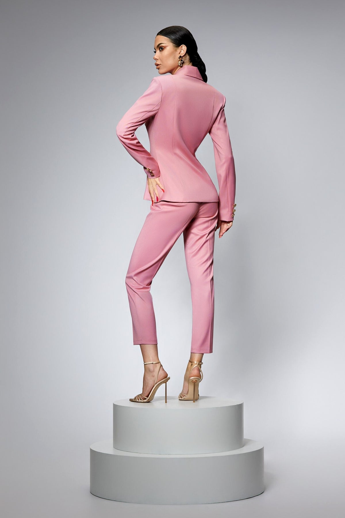 Completo tailleur rosa Bby con giacca doppiopetto, pantaloni e bottoni metallici dorati, stile elegante e alla moda.