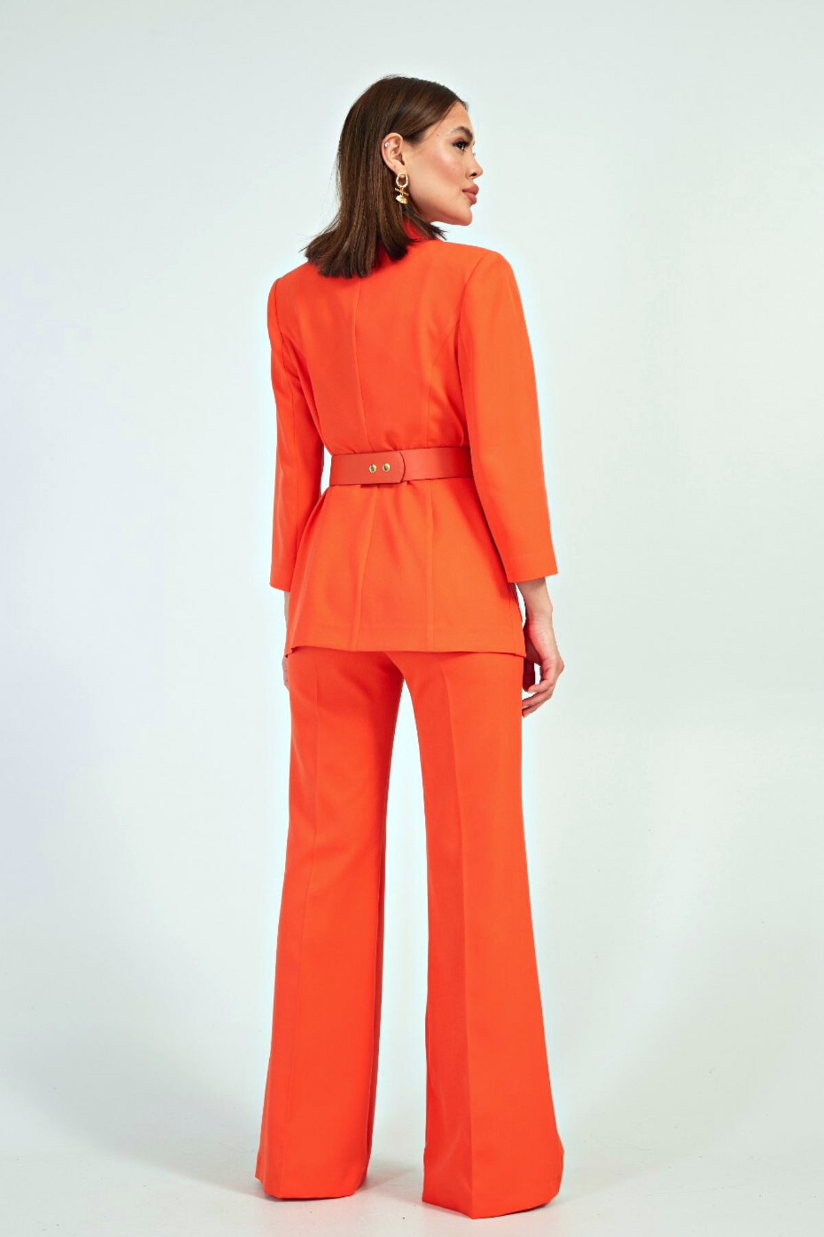 Completo tailleur arancione corallo Moda-Mania con giacca con tasche esterne, cintura e pantaloni larghi.