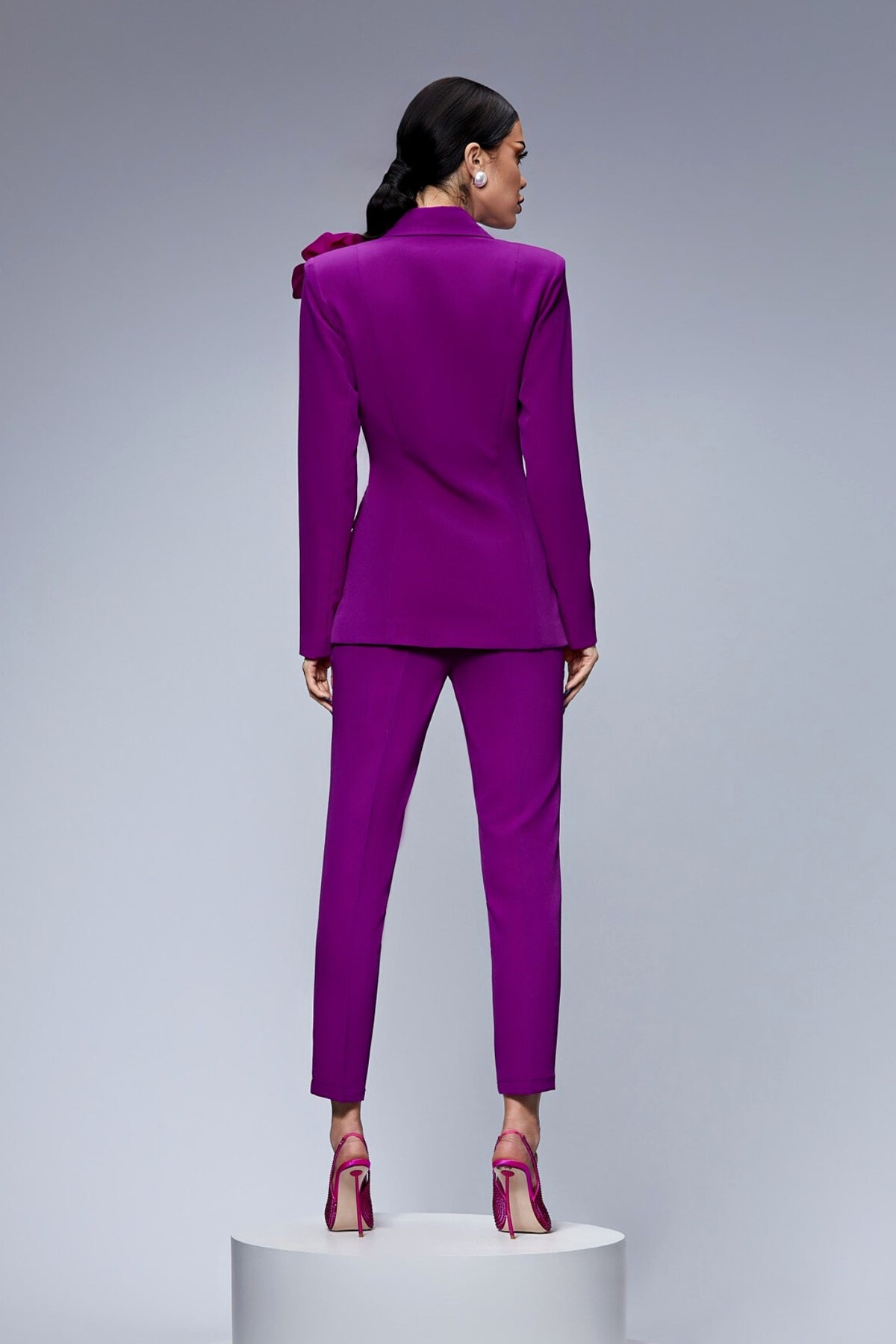 Completo tailleur Bby viola magenta con giacca doppiopetto, spilla fiore e pantaloni a sigaretta, tessuto elegante e moderno.