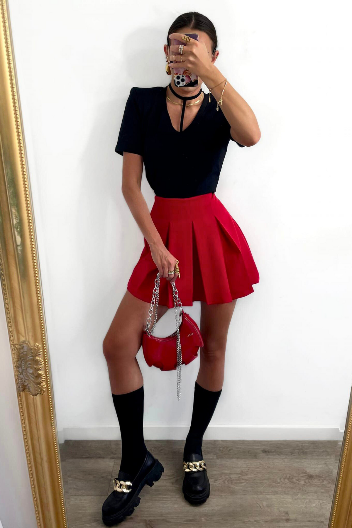 Gonna corta rossa svasata a vita alta con pieghe e pantaloncino interno, marca Moda-Mania, vista frontale.