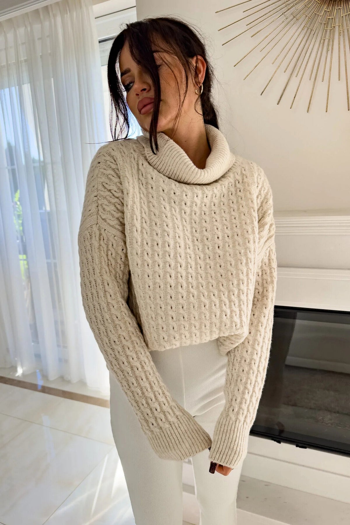 Maglione oversize Moda-Mania in filato morbido beige chiaro con trecce, collo alto e polsini a coste, stile confortevole e elegante.