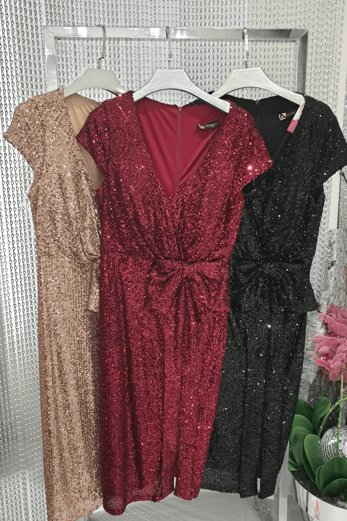 Abito corto bordò a tubino in paillettes Moda-Mania con scollo a V e fiocco decorativo in vita, perfetto per occasioni eleganti.