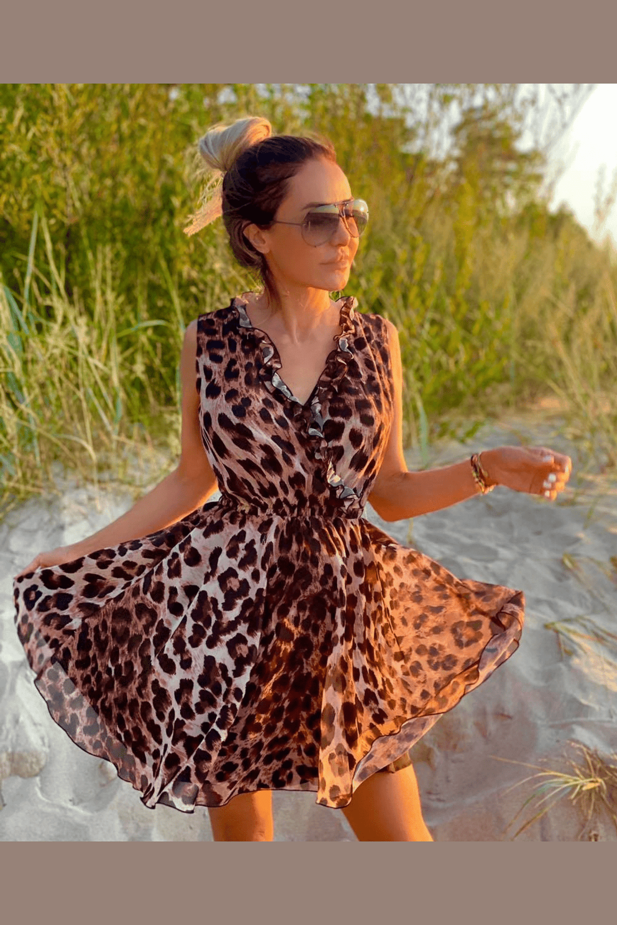 Abito estivo corto casual Moda Mania con fantasia leopardata, scollo a V e dettagli di ruches, indossato su una modella.