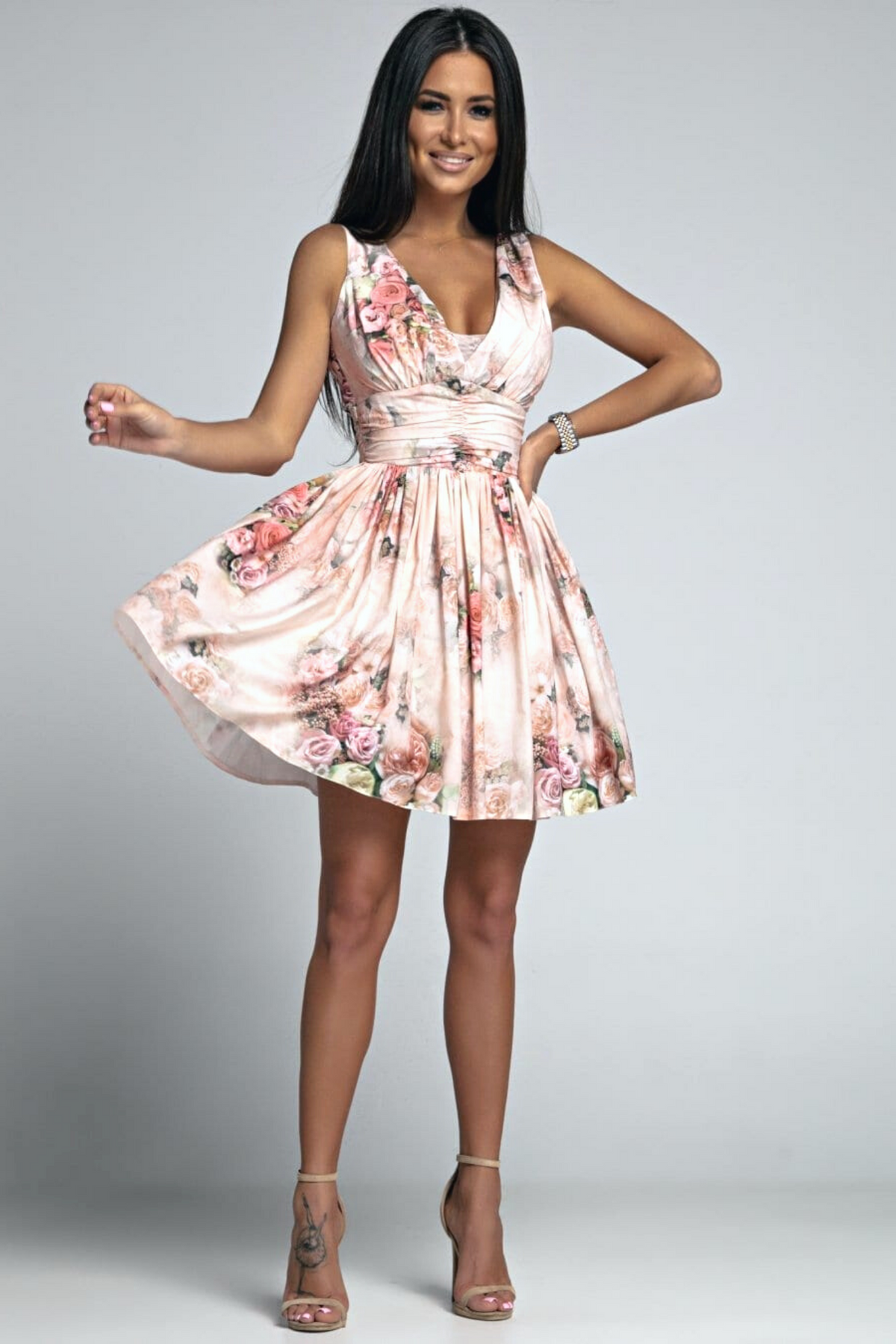 Abito corto svasato pesca chiaro con fantasia floreale e apertura posteriore, marca Moda-Mania, tessuto leggero e femminile.