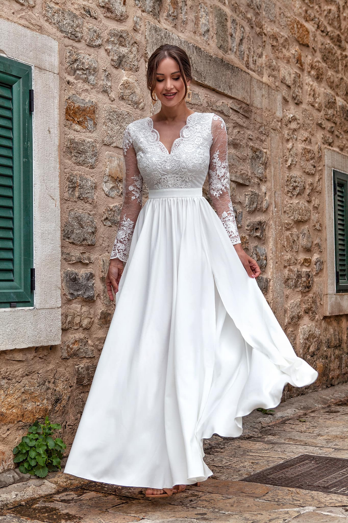 Abito lungo svasato bianco Moda-Mania con spacco laterale e corpetto in tulle ricamato, elegante e femminile.