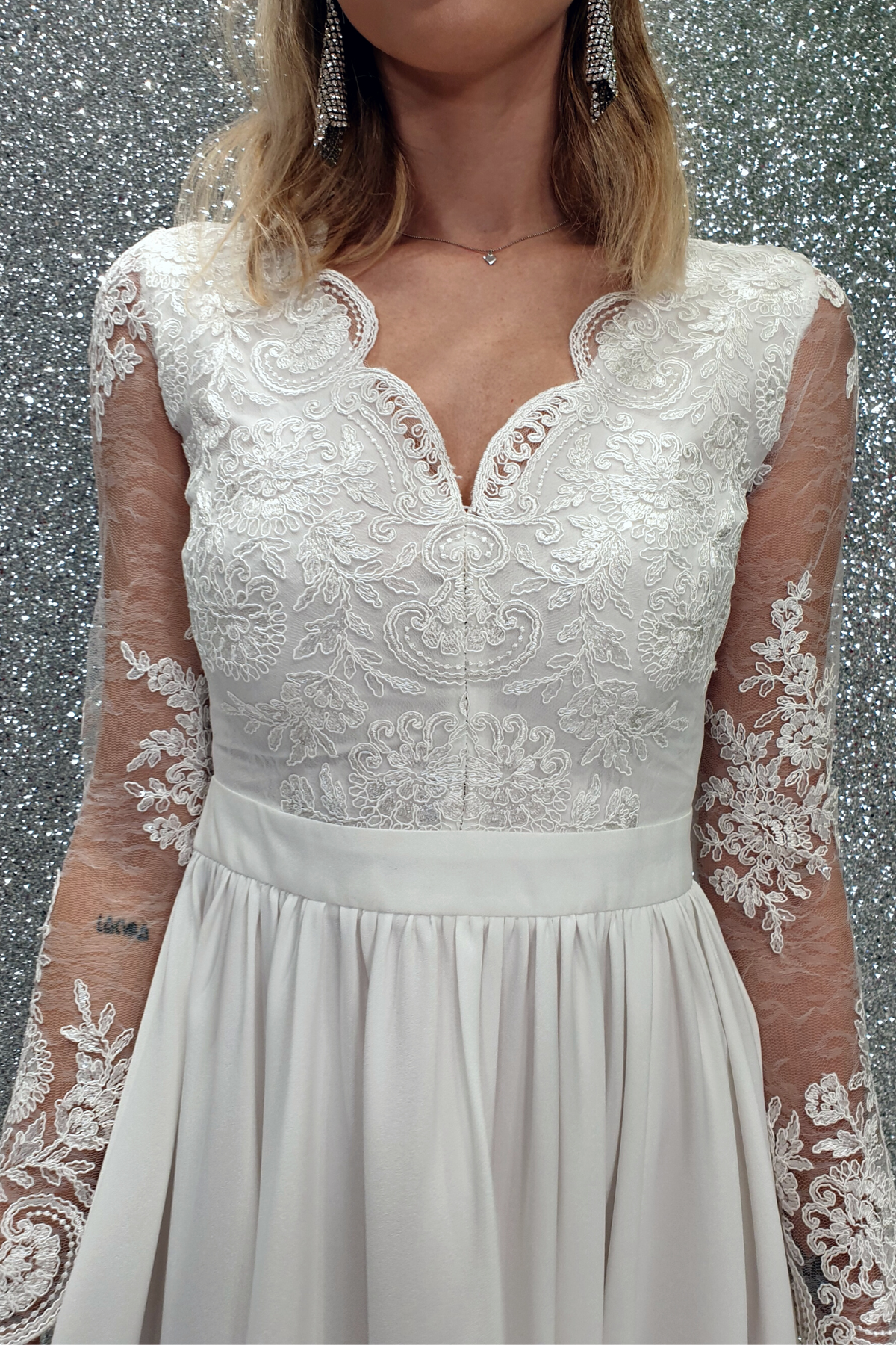 Abito lungo svasato bianco Moda-Mania con spacco laterale e corpetto in tulle ricamato, elegante e femminile.