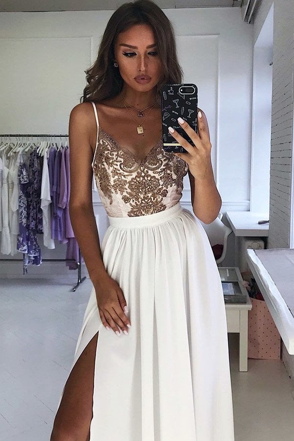 Abito lungo svasato bianco con spacco laterale e corpetto in tulle ricamato dorato, firmato Moda-Mania.