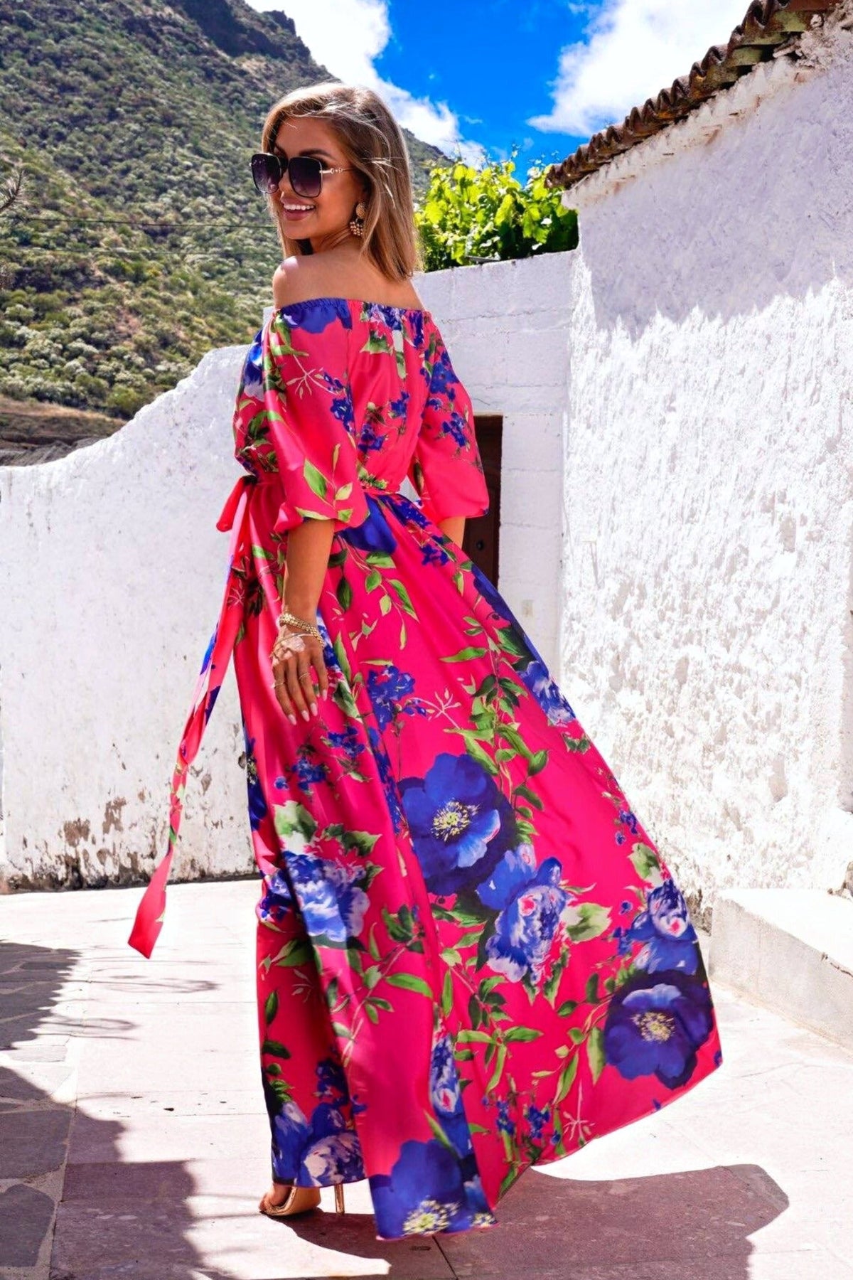 Abito lungo svasato estivo fucsia con fantasia floreale blu, scollo a barchetta, tessuto satinato, moda-mania.